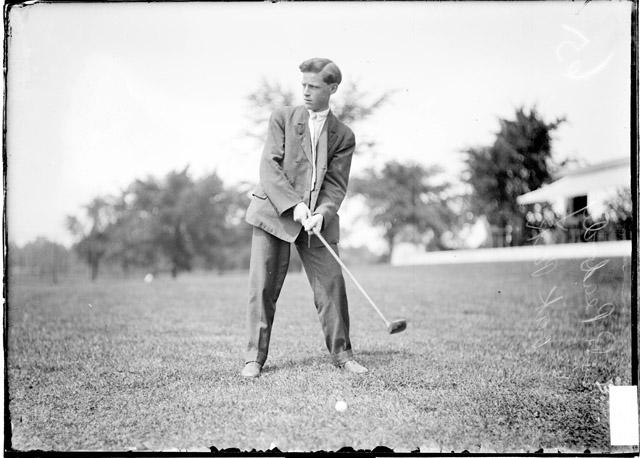 Black and white photo of a man swinging a golf club.